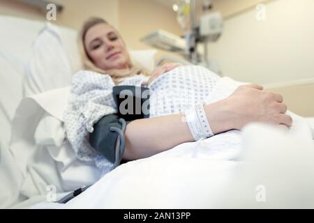 Schwangere Frau im Krankenhaus, Blutdruckmessung, Vorbereitung auf die Geburt, gesundes Schwangerschaftskonzept Stockfoto