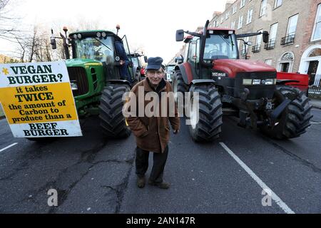 Vincent Black, ein Farmer aus Cavan, zwischen Traktoren, die auf dem Merrion Square im Stadtzentrum von Dublin geparkt wurden, als Protest der Landwirte gegen die Preise, die sie für ihre Produkte erhalten, geht weiter. Stockfoto