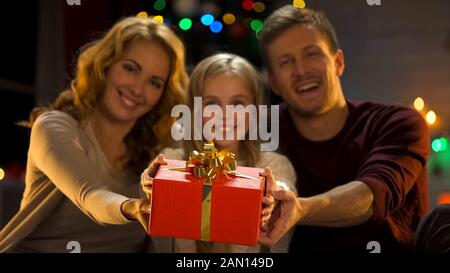 Familie zeigt Geschenk vor der Kamera, Weihnachtszeit für Spenden und Spenden Stockfoto