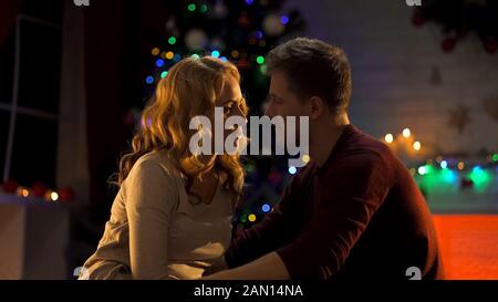 Junges Paar verliebt sich an einem magischen Weihnachtsabend, festlicher Atmosphäre, Romantik Stockfoto