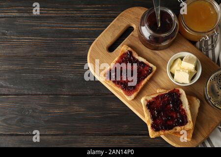 Komposition mit köstlichen Toasts mit Marmelade auf Holzbrett, Platz für Text Stockfoto