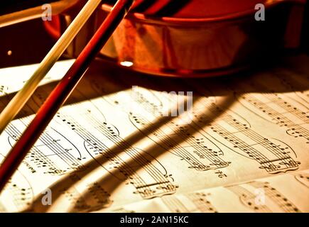 Geige und Noten. Braun vintage Violine und Bogen auf Holz- Hintergrund. Symbol der Orchester Musik. Stockfoto