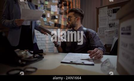 Ermittler des Bundesamtes, der Akten, komplizierte Fälle, Hinweise durchschaut Stockfoto