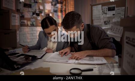 Zwei Verteidiger, die über Nacht arbeiten und Antworten in streng geheimen Akten finden Stockfoto