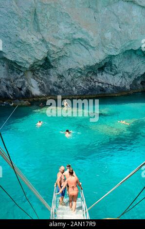 Zakynthos, Griechenland - 25. Mai 2016: Unbekannter Menschen auf Kreuzfahrt Schiff starten Schwimmen am blauen Meer auf der felsigen Ufer Stockfoto