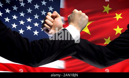 Konfrontation zwischen den USA und China, Uneinigkeit der Länder, Fäuste im Hintergrund der Flagge Stockfoto