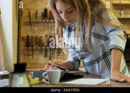 Frau mit digitalen Tablet in Werkstatt Stockfoto