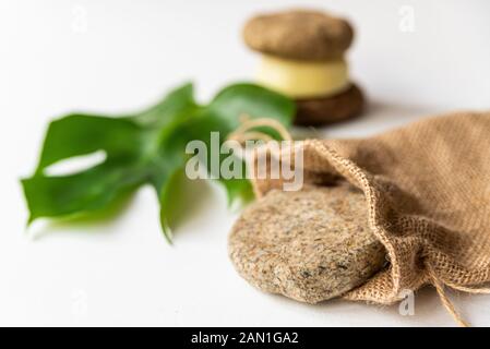 Solid shampoo Disc schließen oben mit grünen Blättern und Jute Tasche Beispiel für natürliche und ökologische Kunststoff frei Kosmetische, hausgemachte mit Kräutern Stockfoto