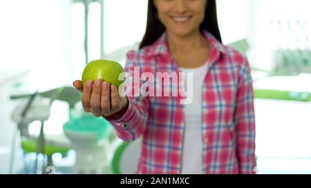 Schöne Mädchen, Green Apple von der Kamera in den zahnmedizinischen Büro, gesunde Zähne Stockfoto