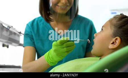 Weibliche Zahnarzt an kleine Mädchen Zähne suchen, Routine zahnmedizinische Überprüfung in der Klinik Stockfoto