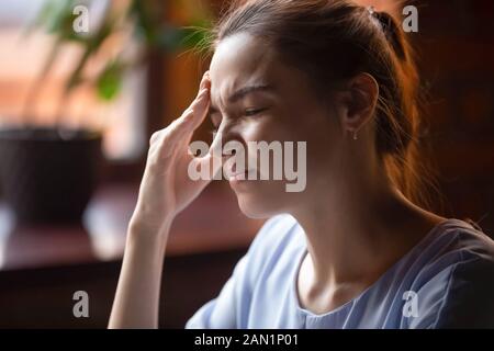 Junge Frauen leiden unter starken Kopfschmerzen Stockfoto