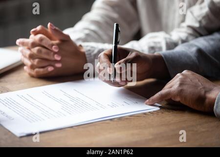 Nahaufnahme des mehrrassigen Paares, das Vertrag mit dem Realtor unterzeichnet Stockfoto