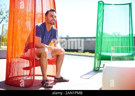Ein Mann sitzt in einem bunten modernen Stuhl. Stockfoto
