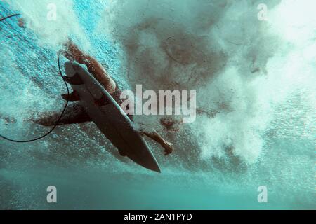 Surfer auf Surfbrett, Unterwasseraufnahme Stockfoto