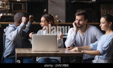 Multirassische Freunde unterstützen verschiedene Teams, die das Spiel in der Bar beobachten Stockfoto