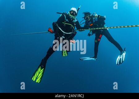 2 Taucher an der obligatorischen 3-minütigen Sicherheitshaltestelle an einer Anlegestelle Stockfoto