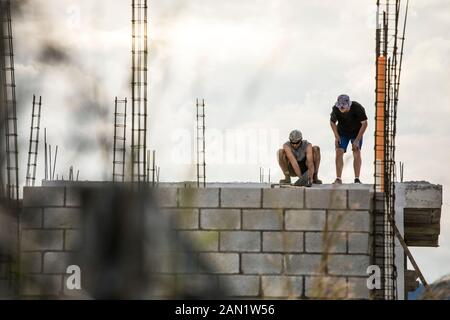 Niedrige Winkelansicht der Bauarbeiter auf dem Dach. Stockfoto