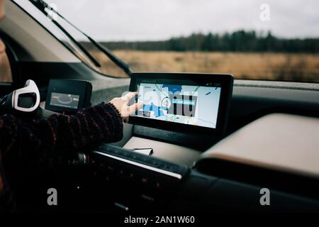 Junge Jungs Hand zeigt auf eine GPS-Navi-Karte in einem Elektroauto Stockfoto