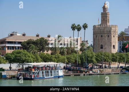 Sevillas Wachturm Torre del Oro mit Blick auf die Bootsstege am Nordufer des Flusses Guadalquivir. Stockfoto