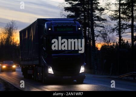 Der blaue Volvo FH-Truck von Kauritel zieht in der Winterdämmerung in Salo, Finnland, Anhänger im Straßenverkehr. Januar 2020. Stockfoto