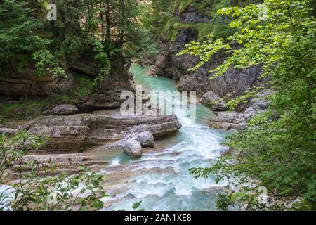 Wildfluss mit blau gefärbten Wasserbächen durch eine Schlucht in den Alpen, Europa Stockfoto