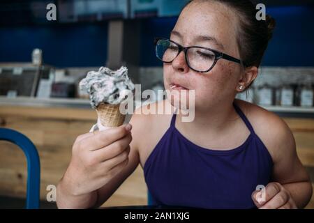 Vorderansicht von Mädchen mit Gläsern Eis essen in Eisdiele Stockfoto