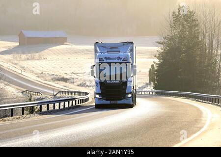 Der weiße Scania der nächsten Generation von Kuljetus Ylilammi Oy zieht auf einem nebligen Wintertag in Salo, Finnland, den Anhänger bergauf entlang der malerischen Autobahn. Januar 2020 Stockfoto