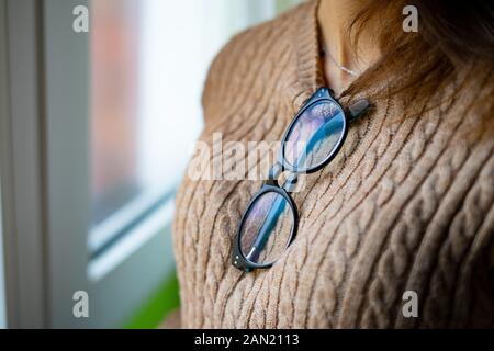 Nahaufnahme von Frau mit Brille hängen an ihren braunen Pullover. Stockfoto