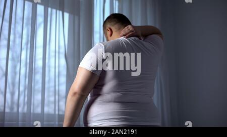 Beleibte Mann stretching Muskeln des Halses, Rückenschmerzen Probleme durch Übergewicht Stockfoto