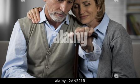 Ältere Paare sitzen auf der Couch, die Ehefrau ihren Mann umarmt mit Liebe, ruhigen Moment Stockfoto