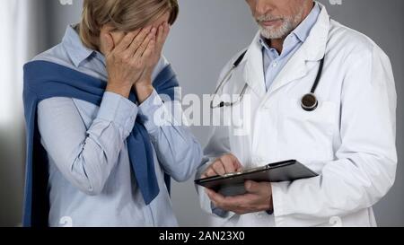 Ältere Frau bitterlich mit Testergebnissen enttäuscht, Arzt, Datensätze Stockfoto