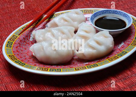 Dim Sum, gefüllte Teigtaschen auf der Platte mit Hilfe von essstäbchen und Sojasauce, Deutschland Stockfoto