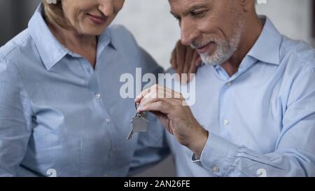 Ältere männliche Holding Hausschlüssel, Dame lächelnd, Immobilien erwerben Stockfoto