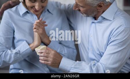 Älterer Mann präsentieren Geschenk glücklich überrascht, Frau, Hochzeitstag zu feiern Stockfoto