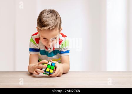 Kind löst einen Rubik's Cube. Konzept der speedcubing puzzle Wettbewerb. Kopieren Sie Platz neben Stockfoto