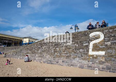 Touristen am Strand und der Strandpromenade auf Barry Island in Wales, Großbritannien. Stockfoto