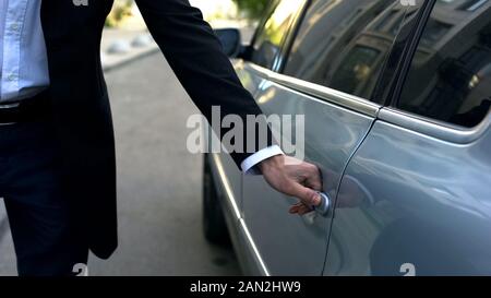 Fahrertür Öffnen der Fahrzeugtür zu Jungen respektable Oligarch, professionellen Chauffeur Stockfoto