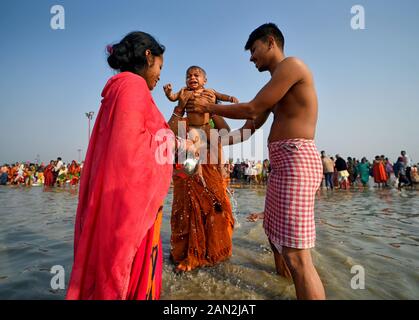 Januar 2020, Namkhana, Indien: Ein junges Paar sah, wie es während des Makar Sankranti Festivals Wasser auf ihr Baby schüttete. Gangasagar ist einer der religiösen Stätten für die Hindu-Pilger an der Bucht von Bengalen, wo jedes Jahr Millionen von Gläubigen während Makar Sankranti ein heiliges Bad nehmen (Übergang der Sonne) gemäß Hindu-Kalender und bitten den Kapil Muni Tempel. Der Termin für dieses Festival liegt normalerweise zwischen dem 13. Und 15. Januar des Jahres. (Bild: © Avishek das/SOPA Bilder über ZUMA Draht) Stockfoto