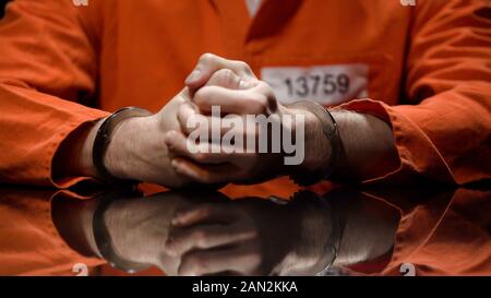 Gefangener in Handschellen ballte die Fäuste, leugnen Quilt, verhörzimmer Stockfoto