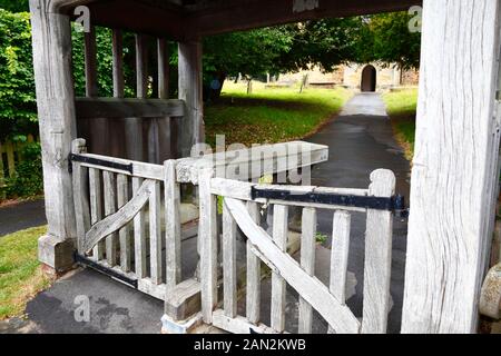 Detail des Holzlychtores mit Holzplatte zum ruhen des Sarges am Eingang zur alten Pfarrkirche von St Peter, Pembury, Kent, England Stockfoto