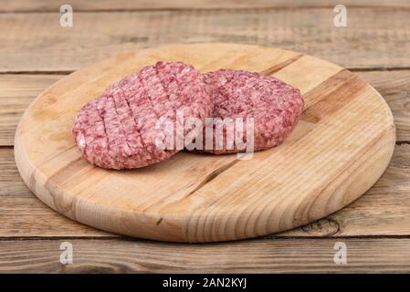 Zwei Rohmaterial rosa Rind Schnitzel auf einem Schneidebrett.. Kopieren Sie Platz. Im rustikalen Stil. Stockfoto