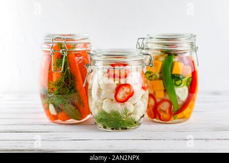 Drei Gläser von fermentierten Blumenkohl, Karotten, Gemüse auf einem hellen Hintergrund. Gärung ist eine Quelle von Probiotika. Stockfoto