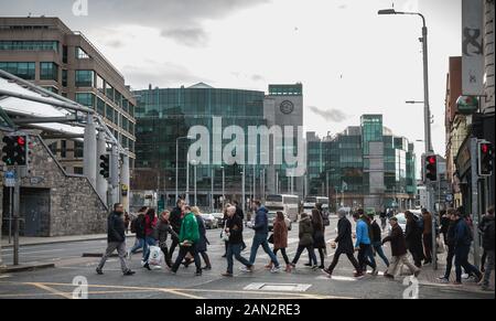 Dublin, Irland - 12. Februar 2019: Gruppe von viele Fußgänger überquert einen Zebrastreifen in der Innenstadt an einem Wintertag Stockfoto