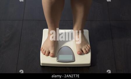 Übergewichtige Mädchen stehen auf elektronische Waagen, Gewichtsabnahme, calorie Control Stockfoto