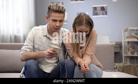 Teen paar Musik hören zusammen, schüchtern beim ersten date zu kommunizieren Stockfoto