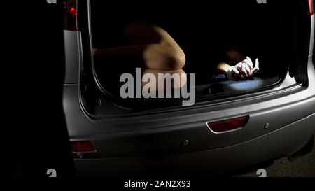 Entführt und Frau in Automobil trunk Lügen, Verbrechen, für lösegeld gebunden, Grausamkeit Stockfoto