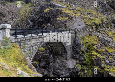 Steinerne Brücke und Wasserfall auf der Trolle Weg Trollstigen oder Trollstigveien scenic Mountain Road in Norwegen Europa. Touristische Route. Stockfoto