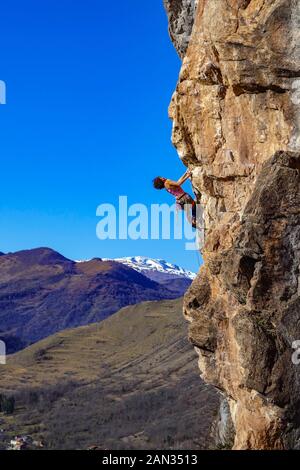 Weibliche Kletterer auf steilen Felsen in Lordat, an sonnigen Wintertag über Ariege Tal, Französischen Pyrenäen, Frankreich Stockfoto