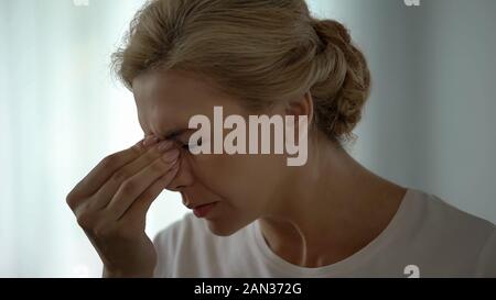 Frau leiden schreckliche Migräne, massieren Nasenrücken, gesundheitliche Probleme Stockfoto