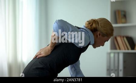 Business Lady Gefühl, Schmerzen im unteren Rücken, Nervenentzündungen, sitzende Lebensweise führen Stockfoto